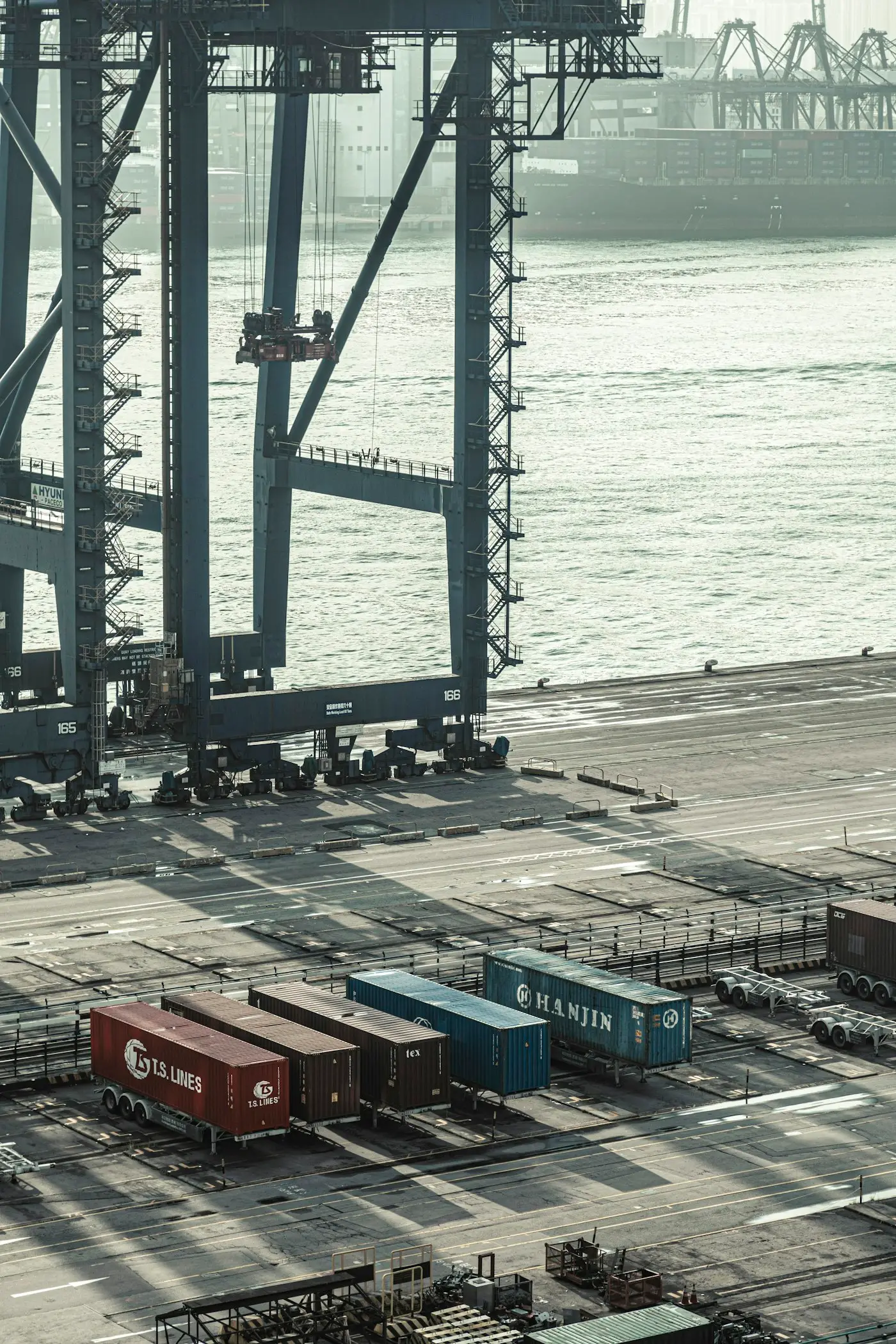 Gantry cranes and shipping containers on a quay by the water